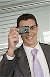 Businessman photographing with cell phone camera