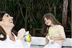 Young woman and girl having breakfast outdoors