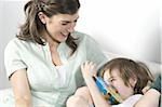 Young woman on couch with boy reading