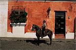 Homme à cheval devant un mur peint typique, Antigua, Guatemala, Amérique centrale