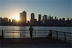 Pêcheur pêche à partir d'un quai de la ville de Jersey à l'aube, face à la Manhattan skyline, Jersey City, New Jersey, États-Unis d'Amérique, l'Amérique du Nord