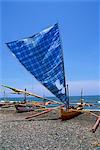 Traditional outrigger boats which fish at night for squid, on the beach during the day, on the island of Bali, Indonesia, Southeast Asia, Asia