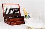Cutlery box with a champagne bottle and tableware on a dining table