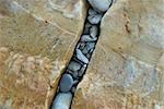 High angle view of pebbles in a gap of rocks