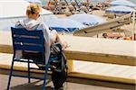 Vue arrière d'une femme assise dans un fauteuil sur la plage, Plage De La Croisette, Cannes, Provence-Alpes-Cote d'Azur, PACA, France