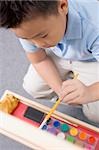 High angle view of a schoolboy painting in an art class