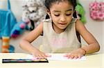 Girl's hands printing on a sheet of paper