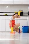 Portrait d'une jeune femme, nettoyer le sol avec une éponge de bain