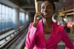 Nahaufnahme einer jungen Frau im Gespräch auf dem Handy an einer u-Bahn-Station