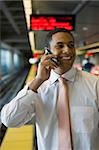 Close-up of a businessman talking on a mobile phone at a subway station