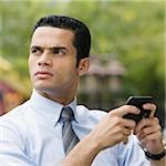 Close-up of a businessman using a personal data assistant and thinking