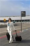 Businesswoman pulling her luggage outside an airport