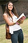 Portrait of a young woman writing in a book and smiling