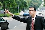 Close-up of a businessman hailing for a vehicle