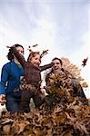 Low angle view of a family playing with leaves