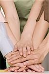 Close-up of office workers stacking hands on a table