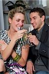 Jeune couple griller avec flûtes à champagne et souriant