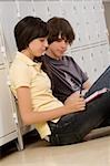 Side profile of a teenage boy and a teenage girl reading a book