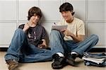 Jeune homme assis avec un adolescent et de l'écriture sur un ordinateur portable