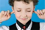 Close-up of a boy with his fingers in his ears