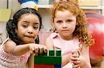 Portrait of two girls playing with plastic blocks