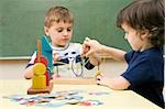 Two boys playing with a buzz wire game