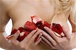 Milieu vue en coupe d'une jeune femme couvrant ses seins avec pétales de rose