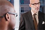 Close-up of two businessmen discussing in an office