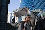 Businessman using his briefcase as a shade