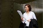 Close-up of a businesswoman reading a newspaper and smiling