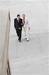 Businessman and a businesswoman walking with their arm in arm