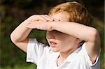 Close-up of a schoolboy shielding his eyes