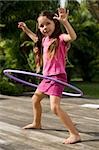 Side profile of a girl playing with a plastic hoop