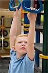 High angle view of a boy hanging on monkey bars