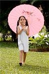 Girl walking in a park with an umbrella