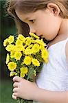 Side profile of a girl holding a bunch of flowers and smelling