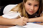 Portrait of a girl writing on a textbook with a pencil