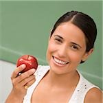 Portrait of a female teacher holding an apple and smiling