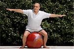 Senior man exercising with a fitness ball