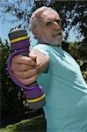 Side profile of a senior man exercising with dumbbells