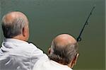 Rear view of two senior men fishing