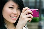 Close-up of a young woman taking a picture with a digital camera