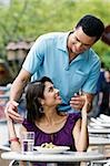 Couple looking at each other and smiling at a sidewalk cafe