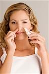 Portrait d'une jeune femme mettant en vaporisateur nasal drops en son nez