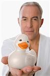 Portrait of a senior man holding a toy duck