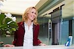 Businesswoman standing at the hotel reception and smiling