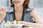 Close-up of a young woman eating salad