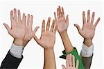 Close-up of business executives raising their hands