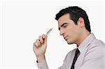 Side profile of a businessman holding a pen and thinking