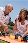 Senior couple enjoying juice at picnic